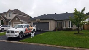 roofing project complete, dark roofed bungalow, A1 Pro roofing truck sits in the driveway - A1 Pro Roofing Ottawa Kanata Orleans