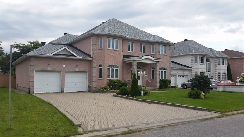roofing project complete, two-story brick house with light gray shingled roof - A1 Pro Roofing Ottawa Kanata Orleans